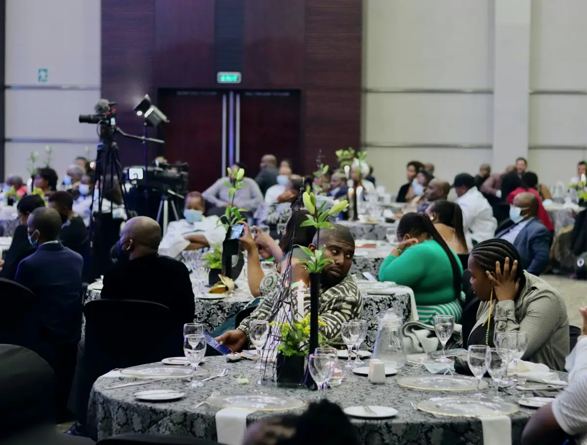 Delegates seated at round tables during a large conference