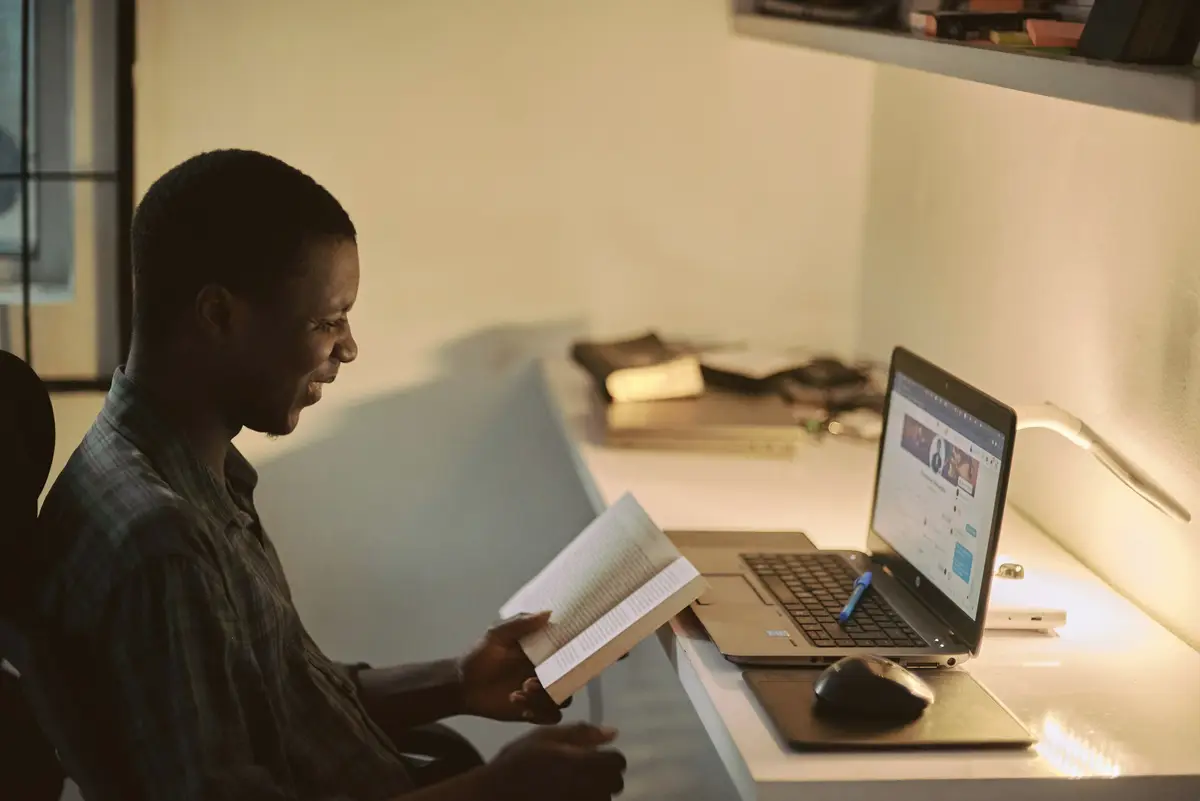 A consultant reading through documents at a desk with a laptop